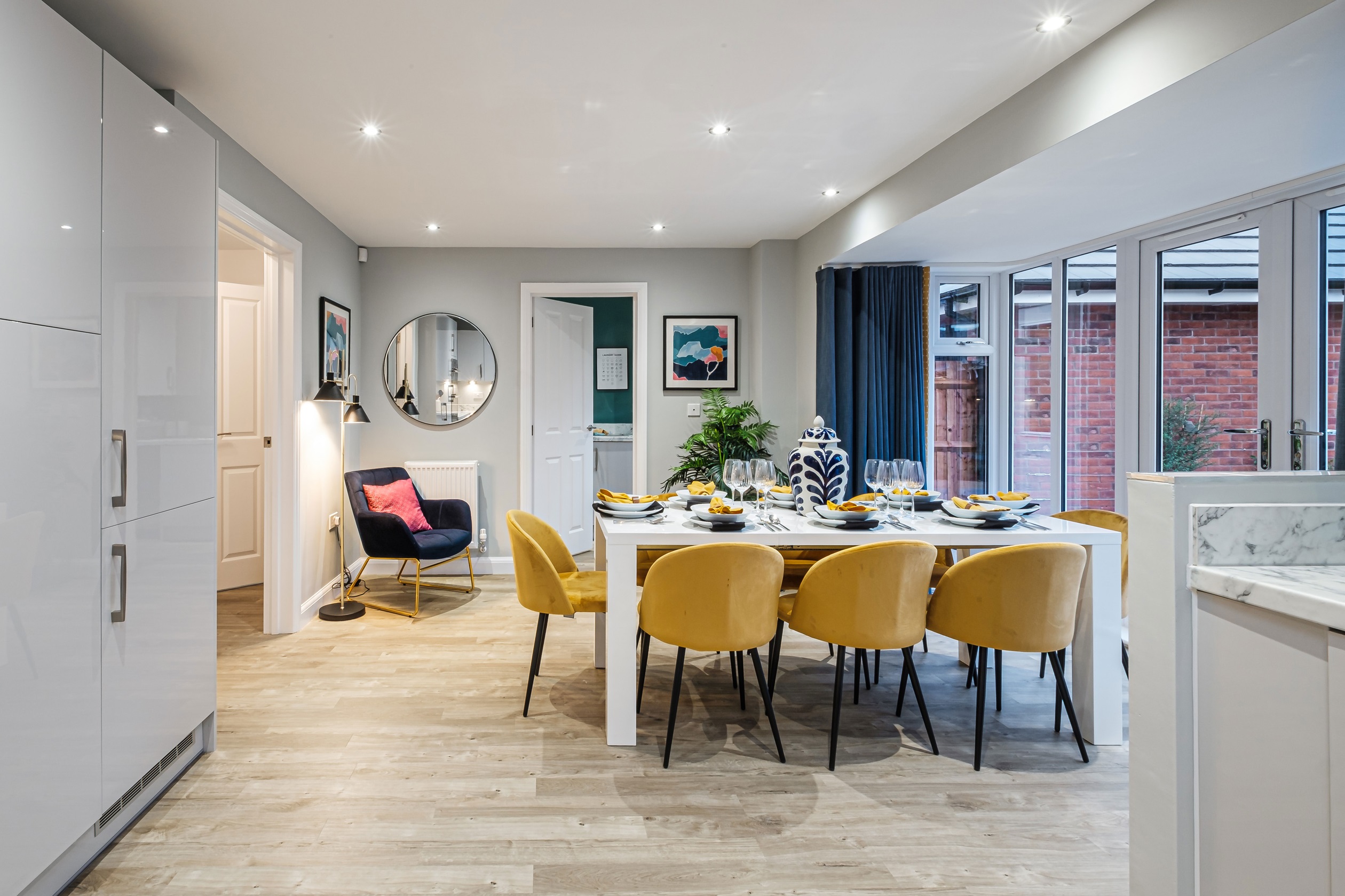 Dining area with yellow chairs and French doors to the garden