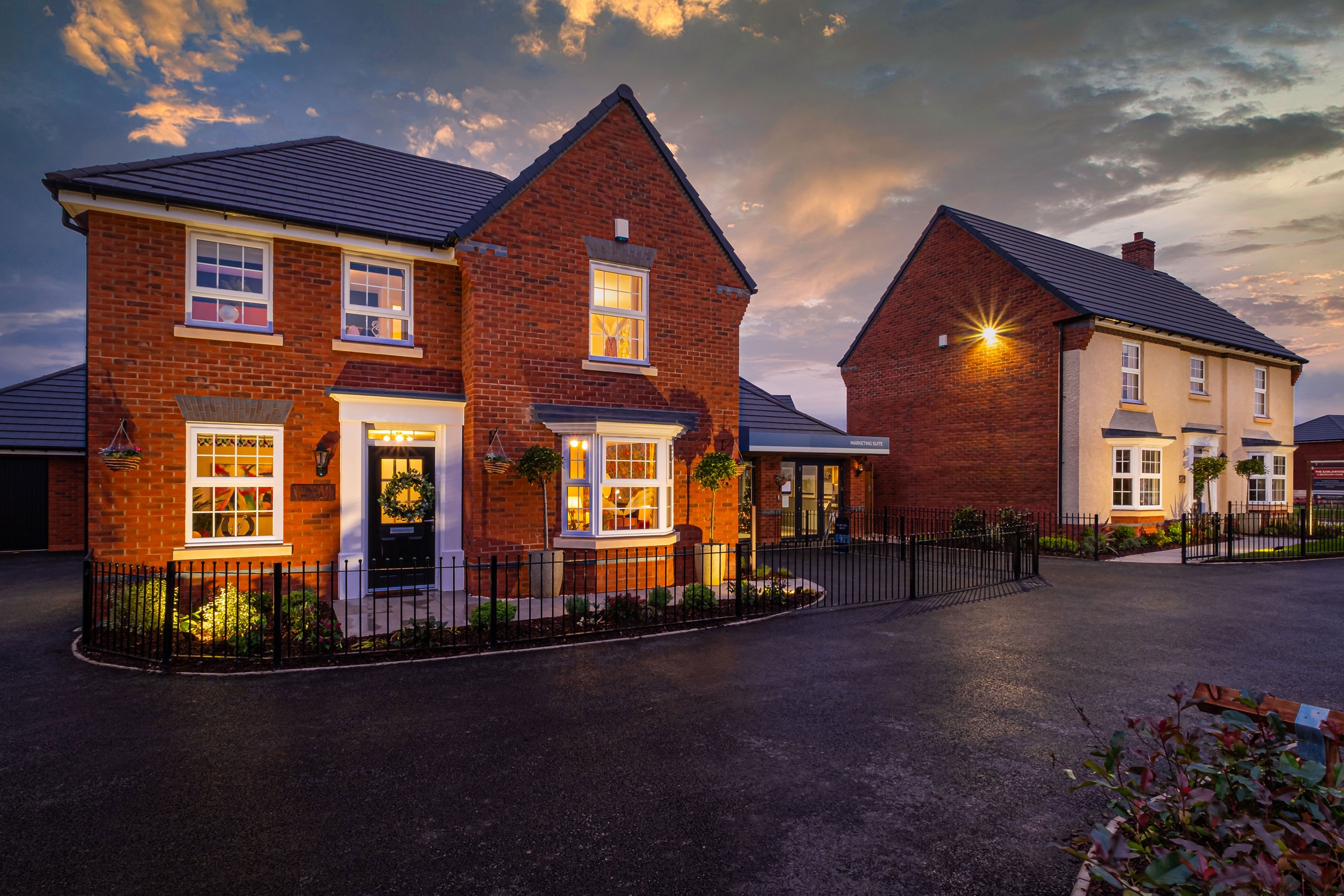 Two detached show homes lit up at dusk