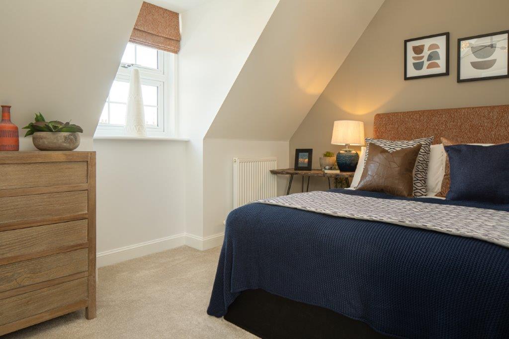 Blue themed double bedroom with sloped ceiling