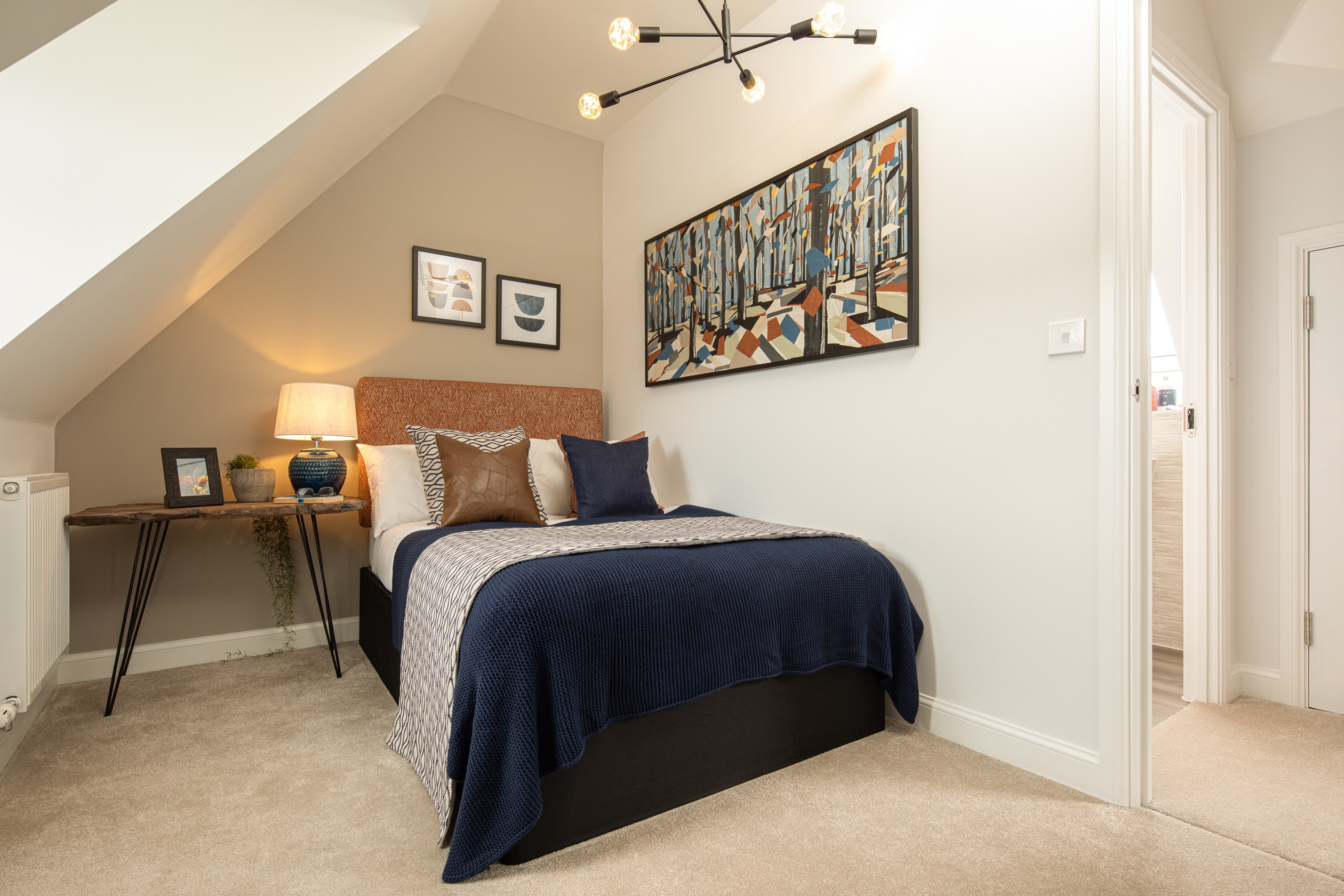 Bedroom with sloped ceiling, beige wall and navy bedding