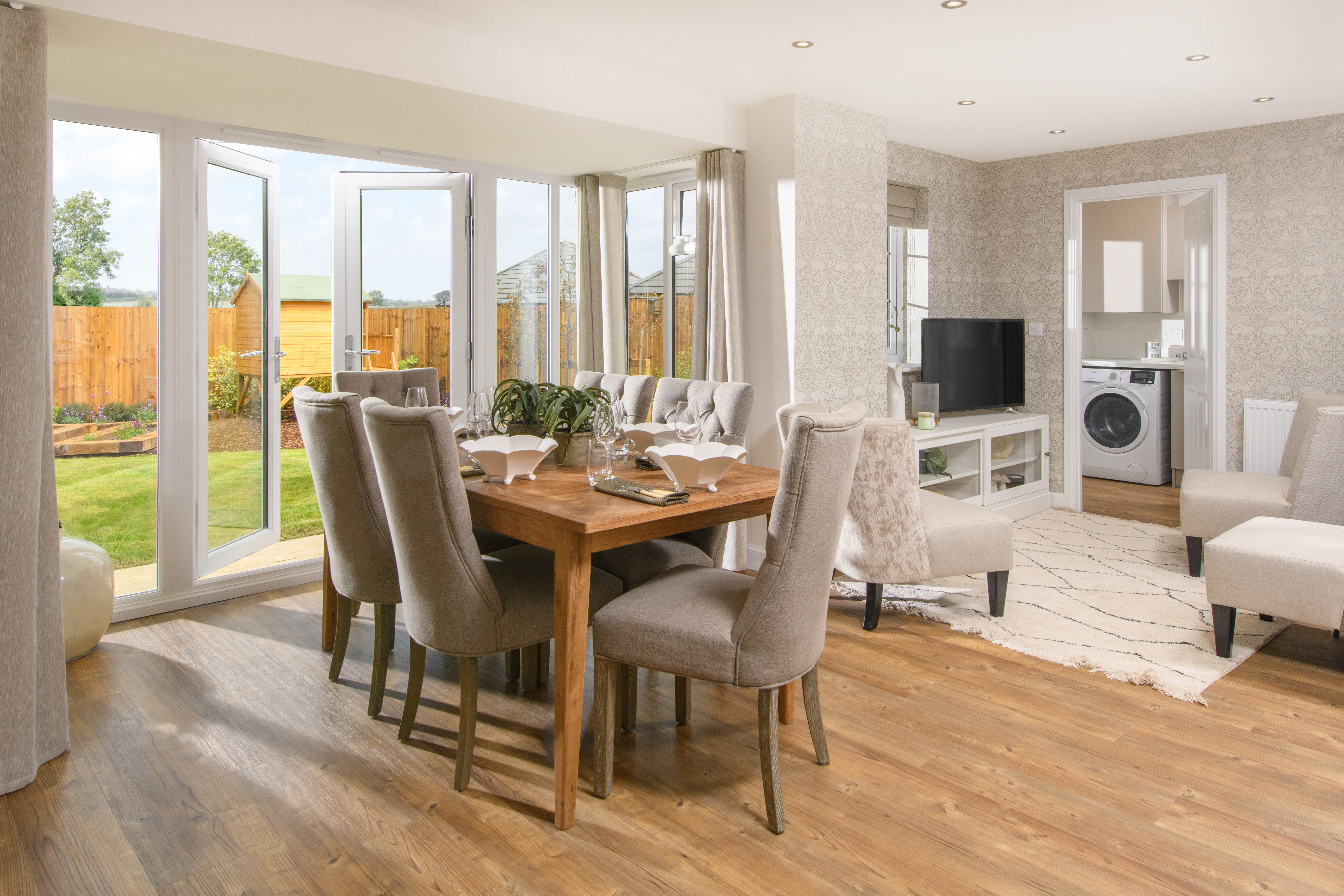 Open-plan kitchen with integrated appliances, dining area & family room with French doors leading onto garden & separate utility room