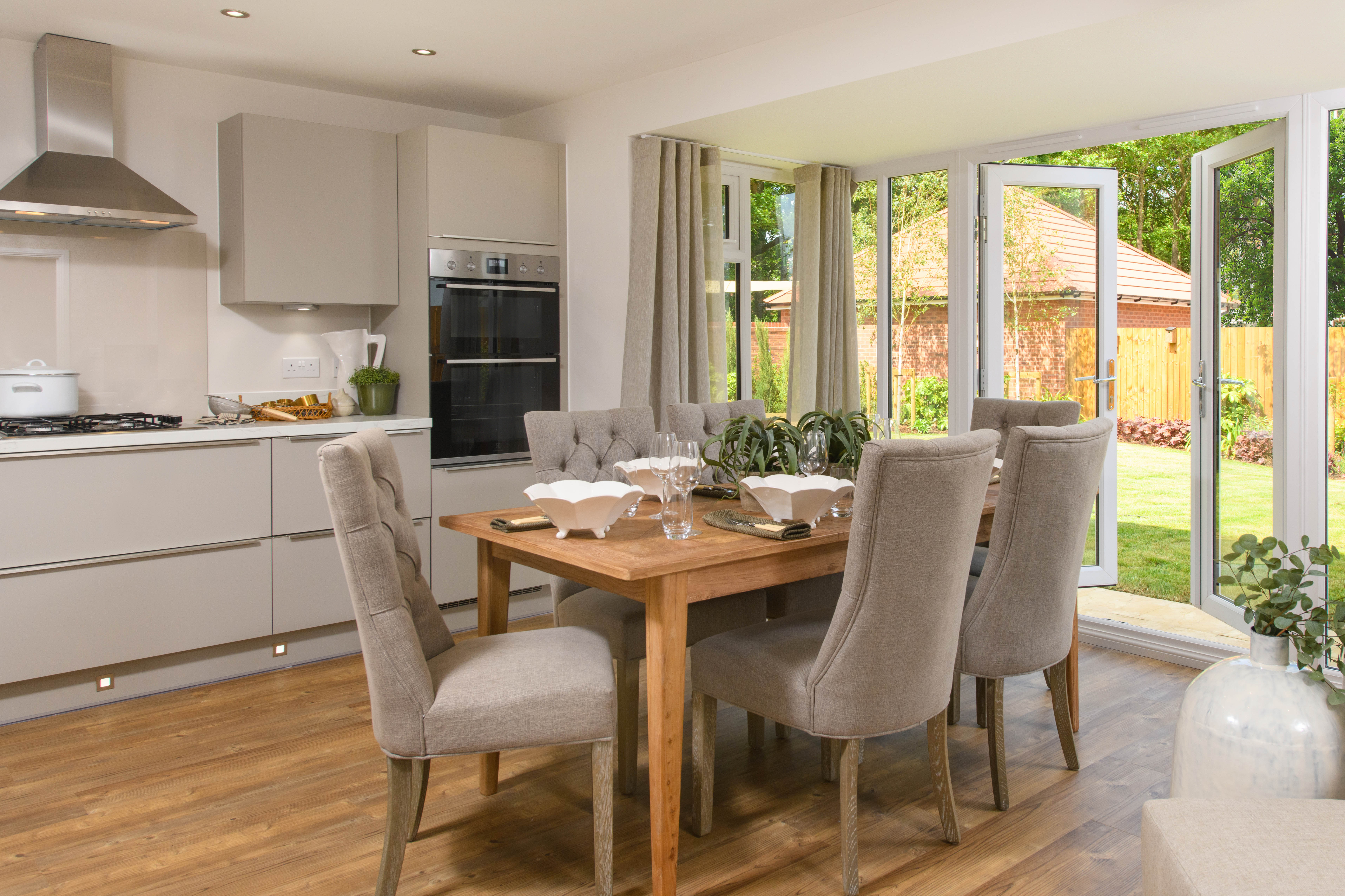 Open-plan kitchen with integrated appliances, dining area & family room with French doors leading onto garden & separate utility room