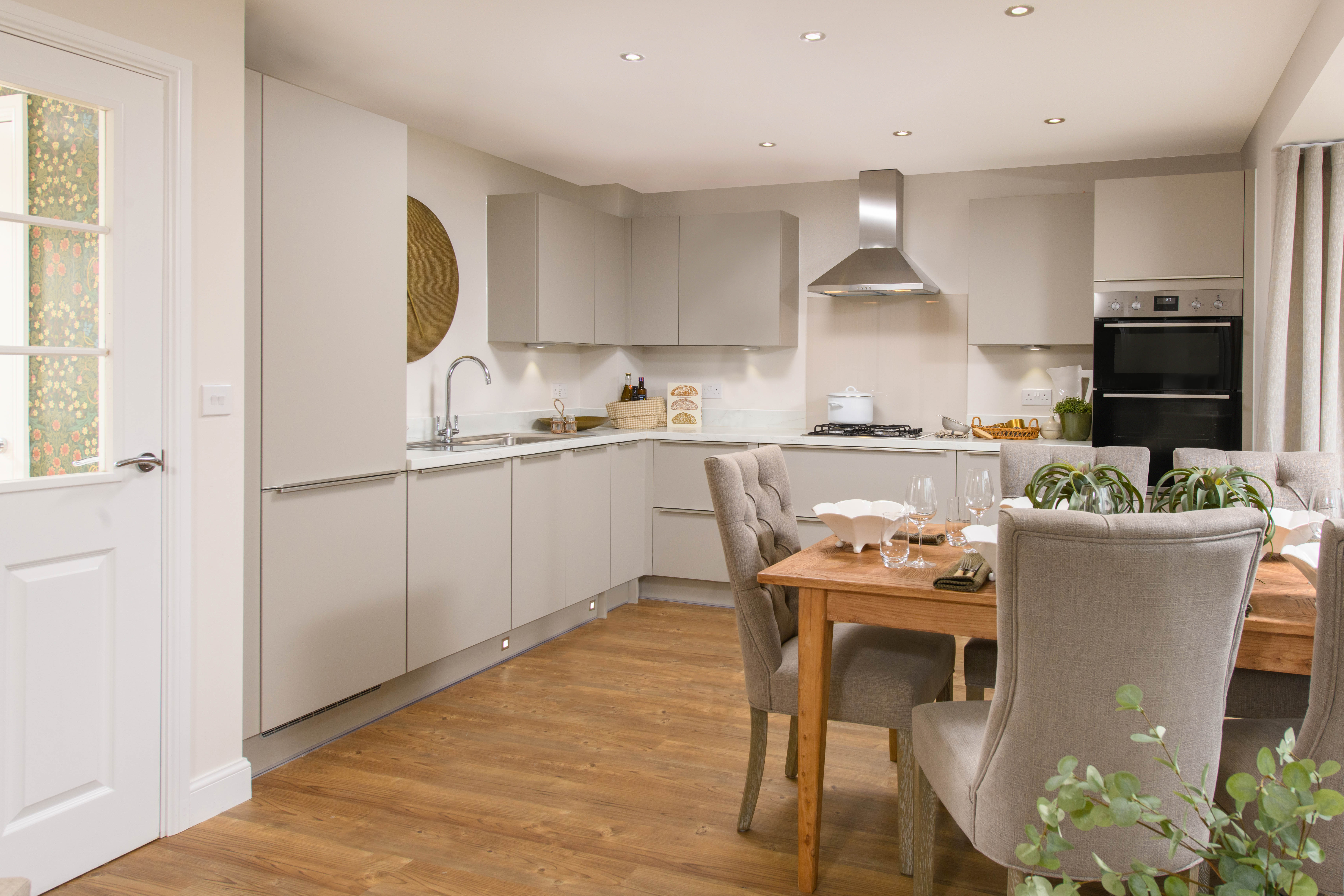 Open-plan kitchen with integrated appliances, dining area & family room with French doors leading onto garden & separate utility room
