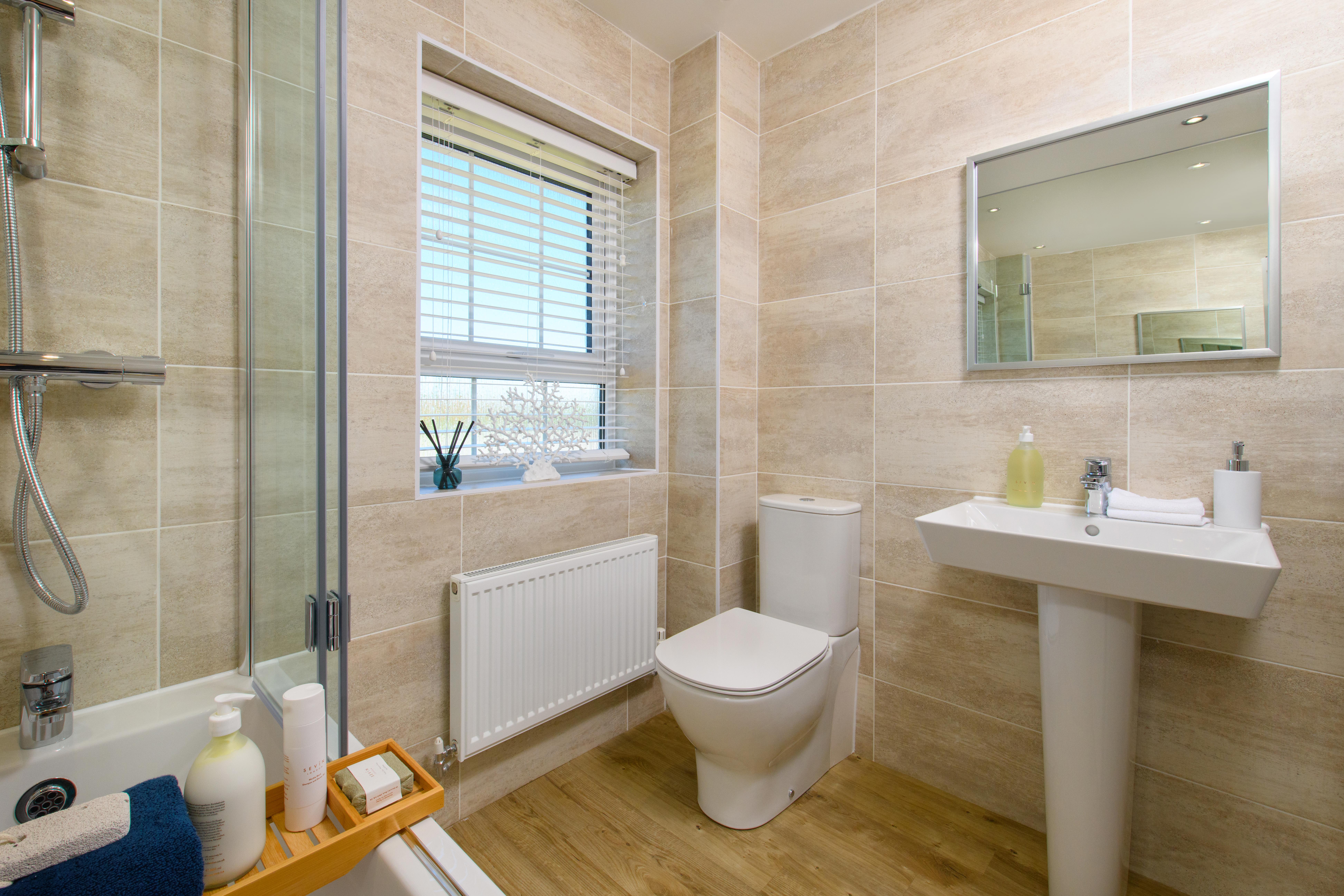 Family bathrom with shower over bath in Bradgate style home