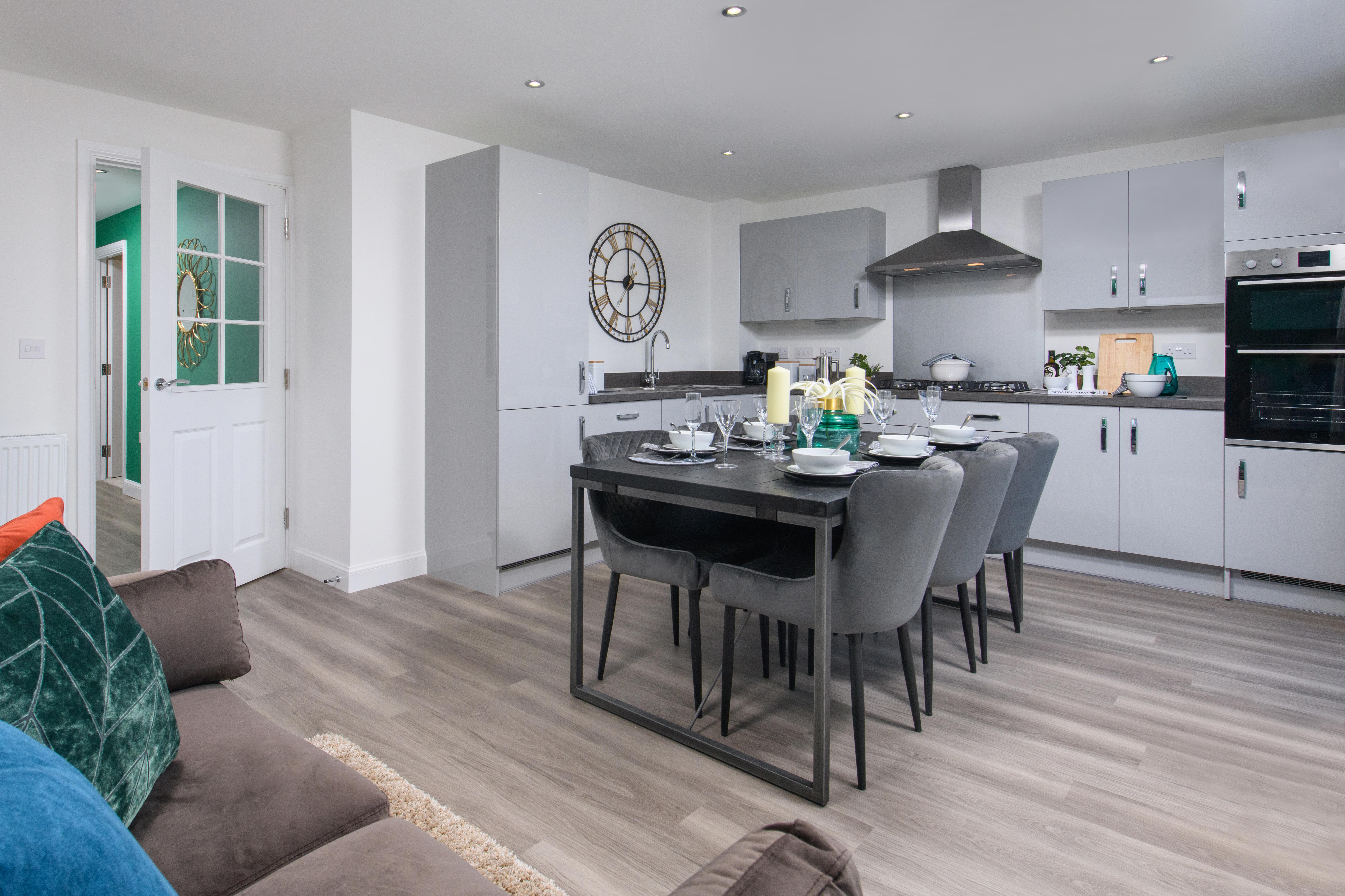 Open-plan kitchen/diner with integrated appliances and French doors leading onto garden in Ingleby style home