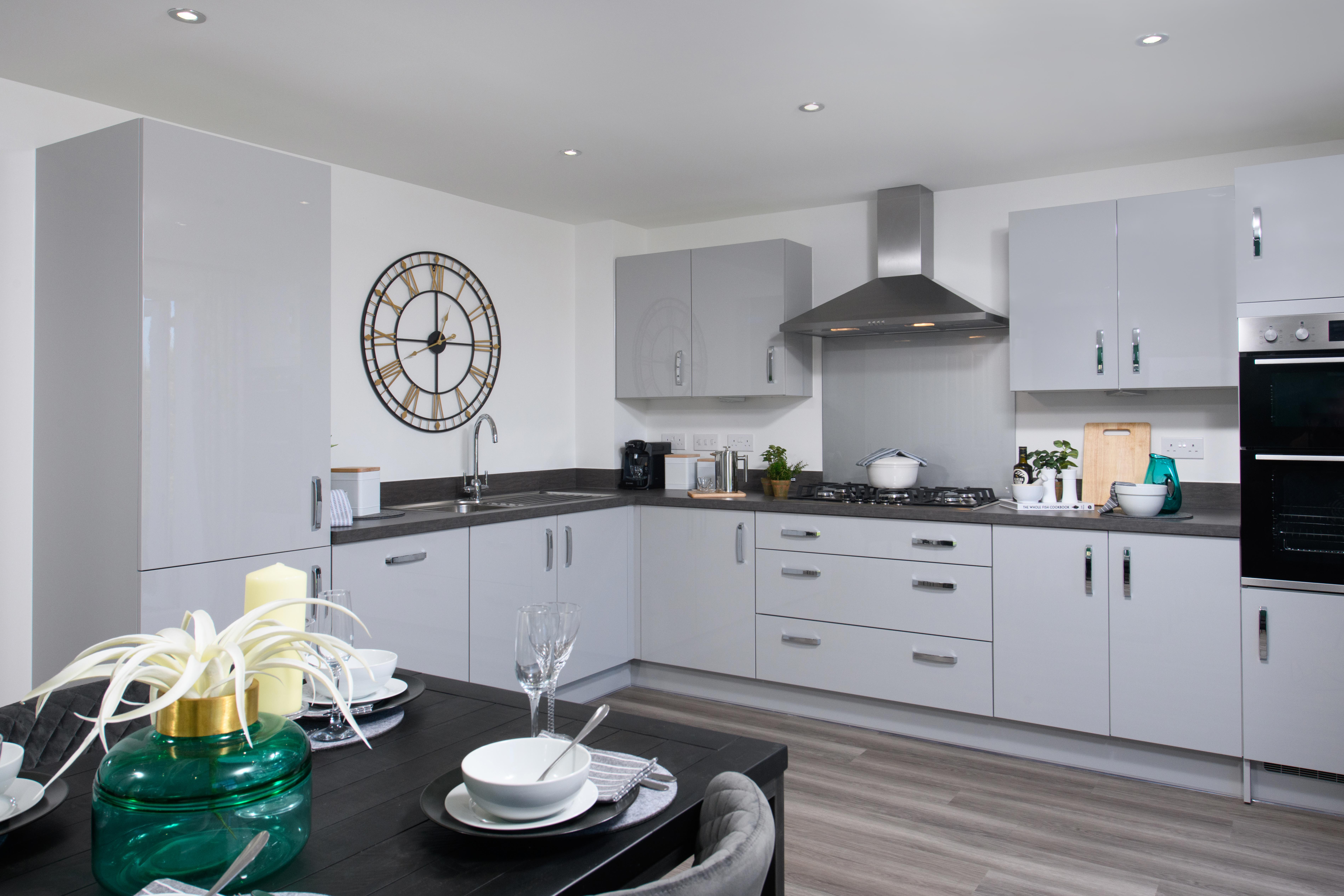 Open-plan kitchen/diner with integrated appliances and French doors leading onto garden in Ingleby style home