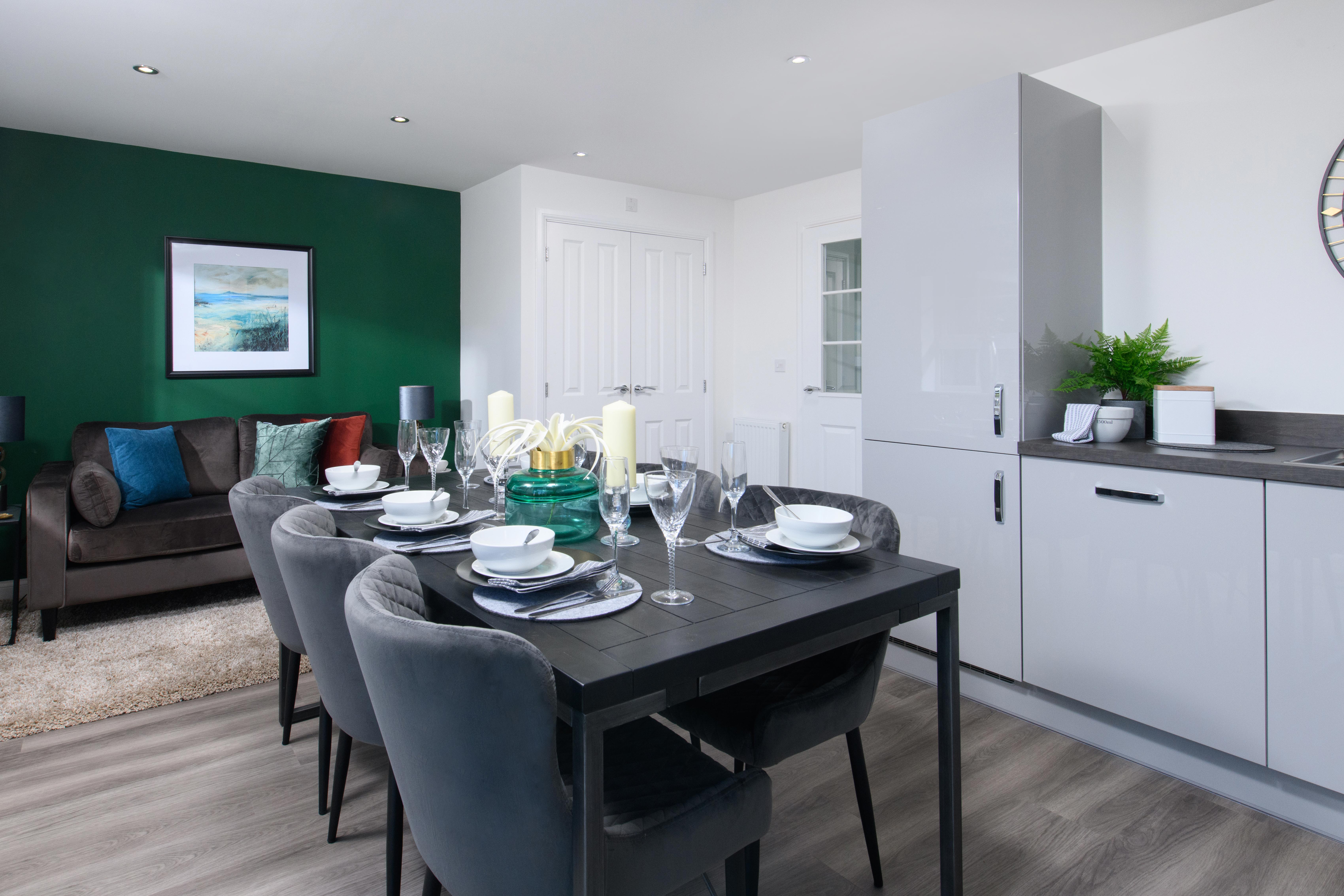 Open-plan kitchen/diner with integrated appliances and French doors leading onto garden in Ingleby style home