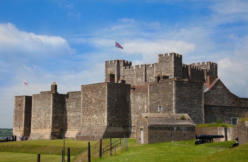 Picture taken of old English Heritage Dover Castle in Kent with flag raised and clouds in the blue sky