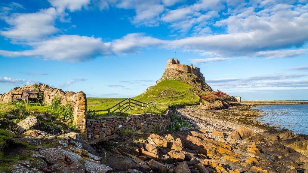 Picture taken of the holy island of Lindisfarne with rocks and the ocean nearby. 
