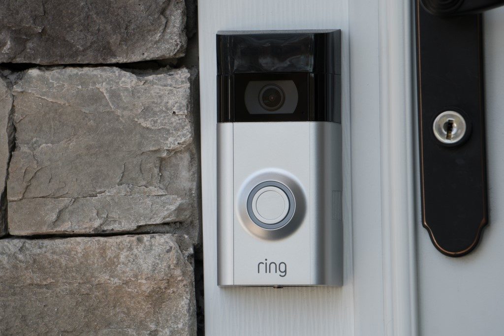 picture of ring smart doorbell with camera next to stone wall