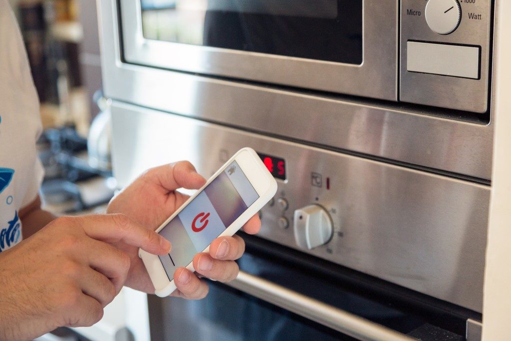 picture of smart oven being activated through mobile phone app